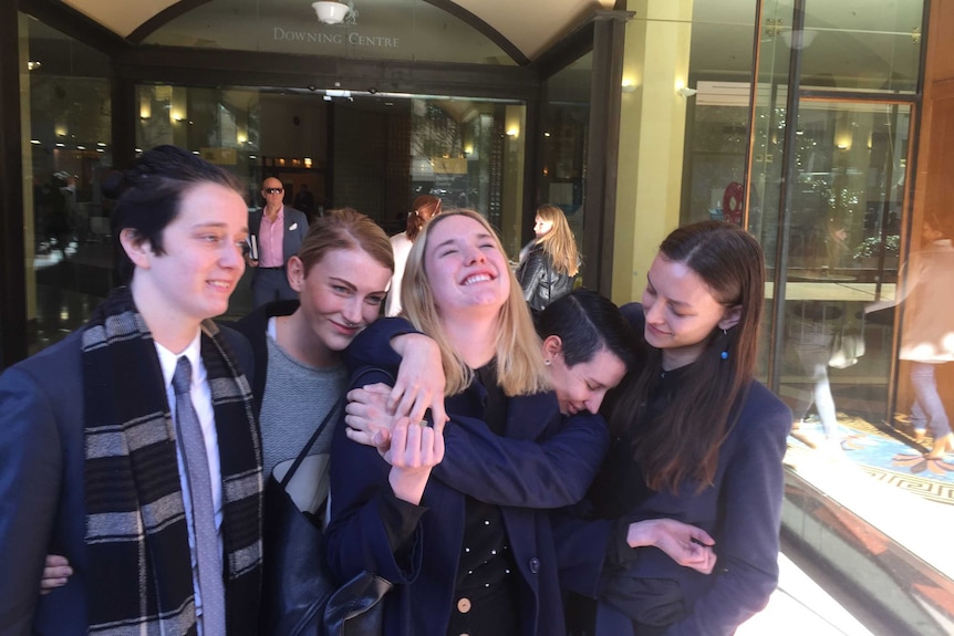 Paloma Brierly Newtown surrounded by four friends laughing and looking elated.