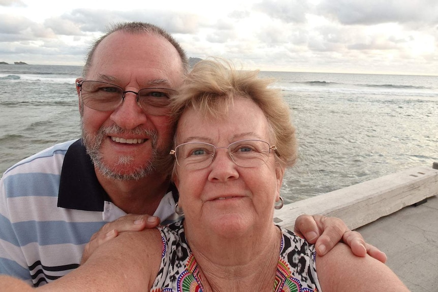 David and Luella Wait smiles standing on a jetty by the ocean on Norfolk Island.