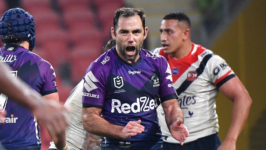 A man dressed in purple shouts on a football field.