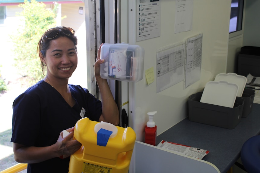 woman carrying medical supplies and smiling