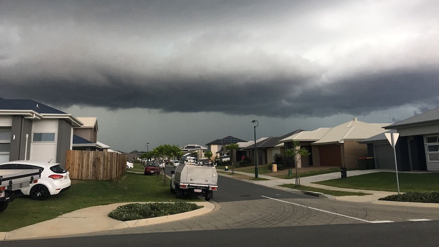 Black clouds cover the sky above a residential street in Mango Hill.