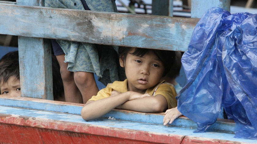 Young asylum seeker girl stares out from a boat