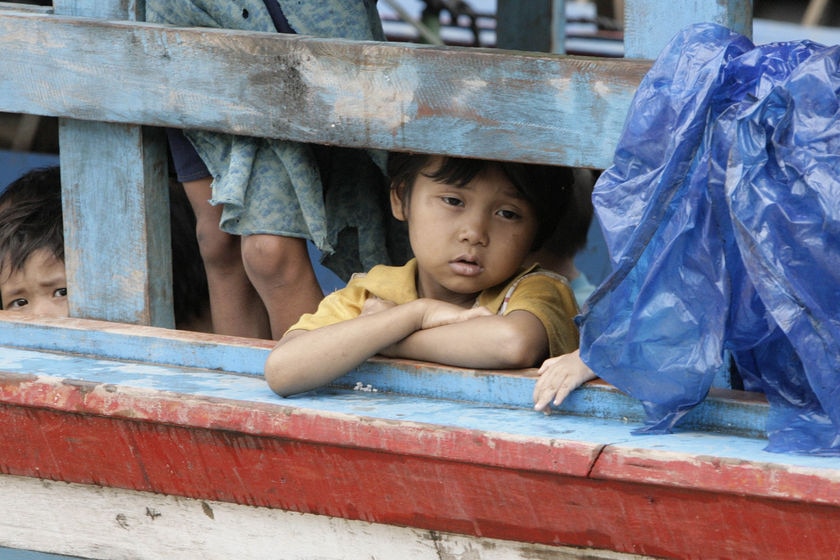 Young asylum seeker girl stares out from a boat