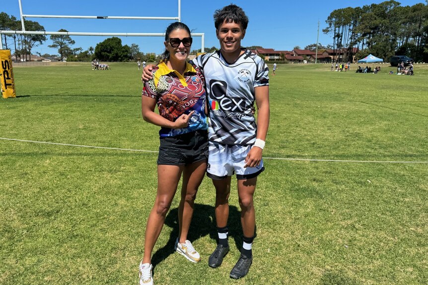 Kristal Kinsela and Kaylan Morris standing together at a rugby ground.