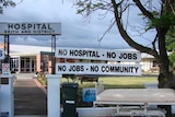 Signs reading 'No hospital, no jobs. No jobs, no community' are pinned to the Keith and District Hospital entryway.