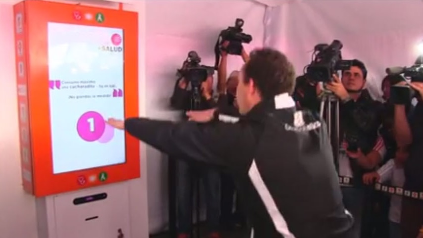 Man squats in front of ticket machine