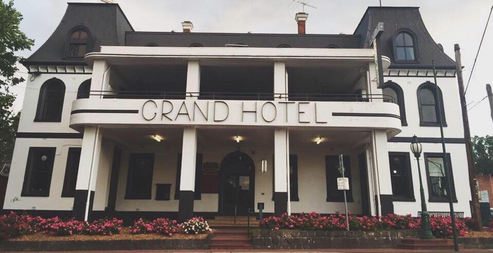 A picture of the front of a pub with a sign saying "Grand Hotel"