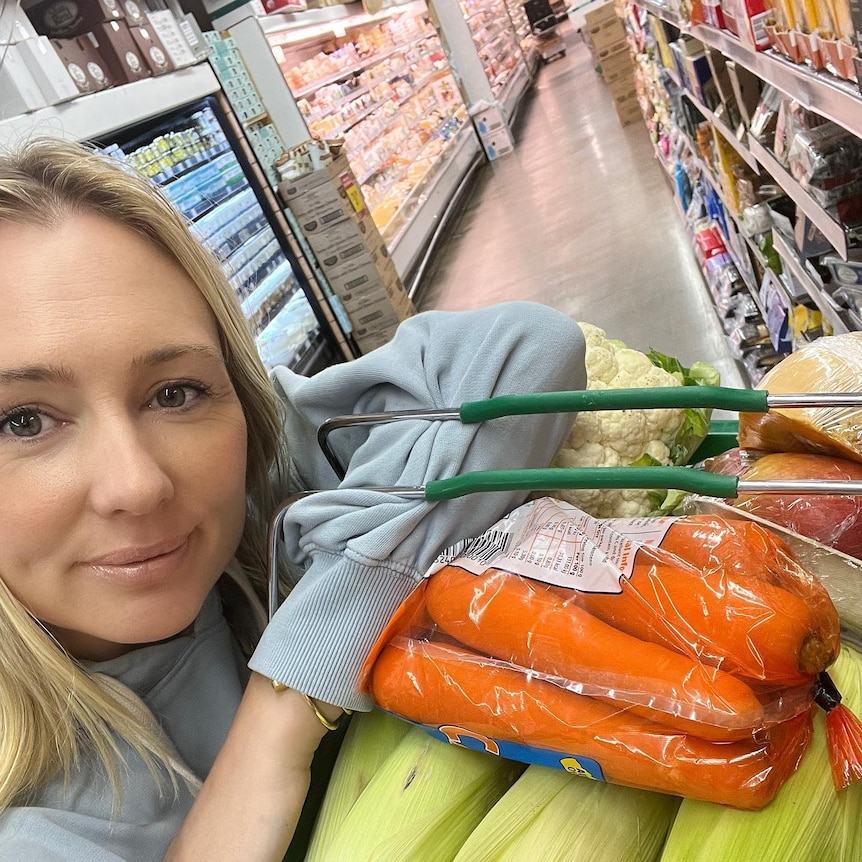 Canna Campbell at the supermarket holding a basket of vegetables