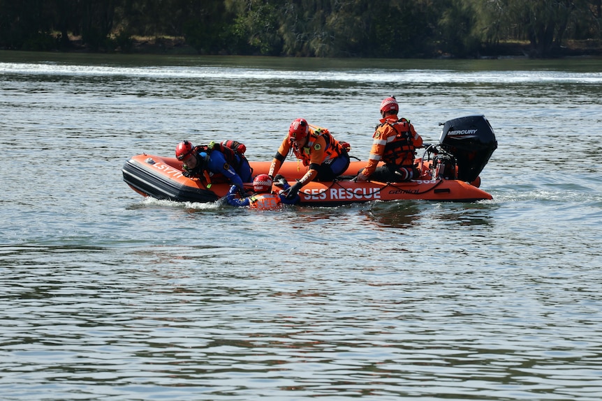state emergency service rescuers in a boat on the water perform a rescue