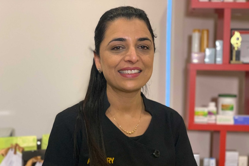 Preet Cheema smiles at the camera from her work, while wearing a black uniform.