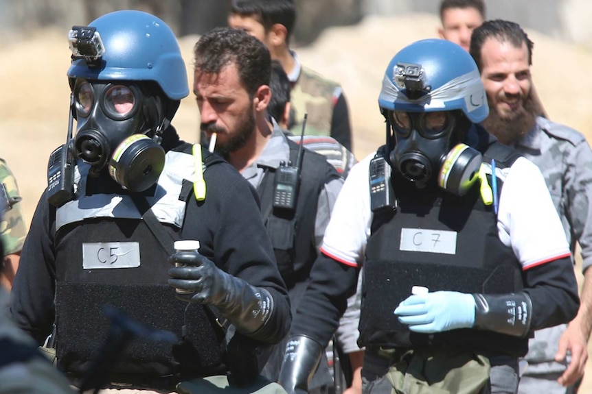 UN chemical weapons experts carry samples from one of the sites of an alleged chemical weapons attack outside Damascus.