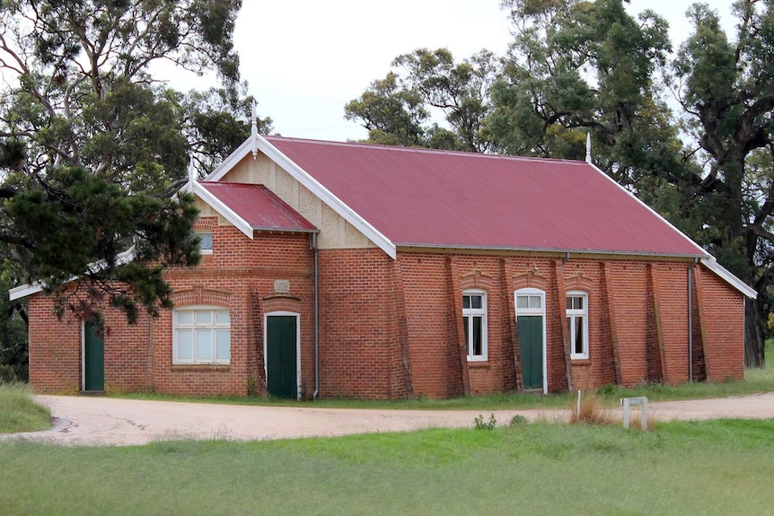 A brick hall with a red roof