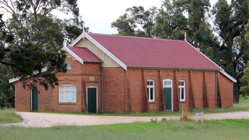 A brick hall with a red roof