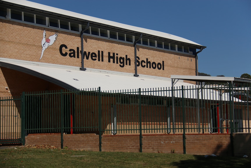 A sign reading Calwell High on a brick wall 