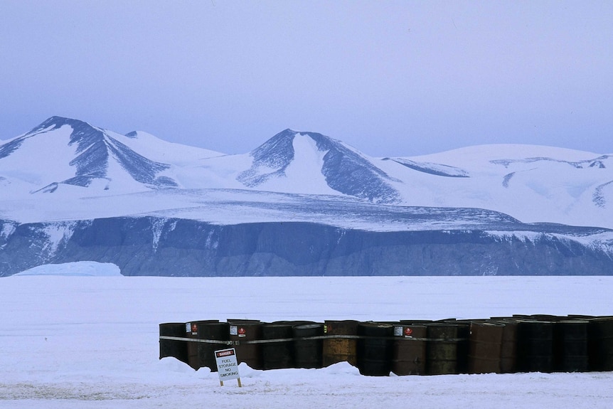 Forty four gallon drums of fuel in snow.