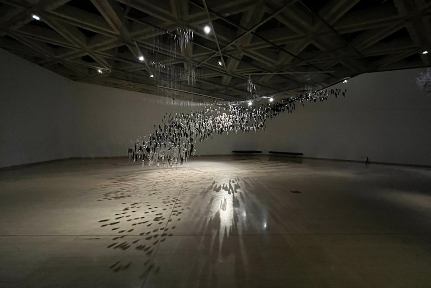 Glass artwork showing cloud of black and white glass yams hanging from ceiling