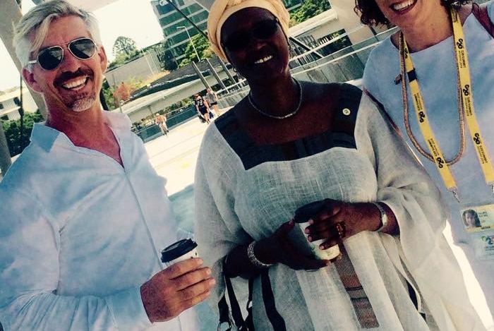 Un homme souriant avec deux femmes.