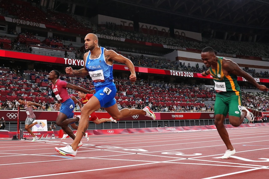 Lamont Jacobs clenches his fist as he crosses the finish line in the 100m final at the Tokyo Olympics.