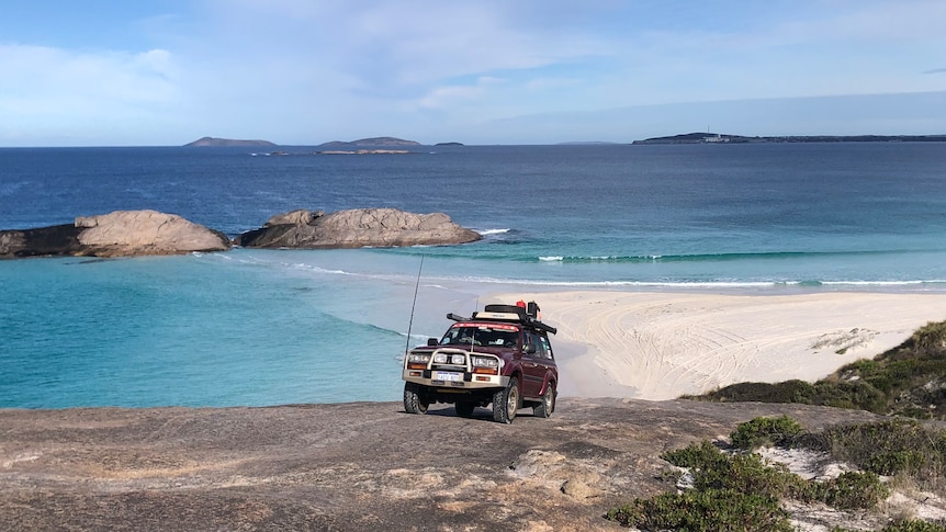 A four-wheel drive driving on a rock over the beach 