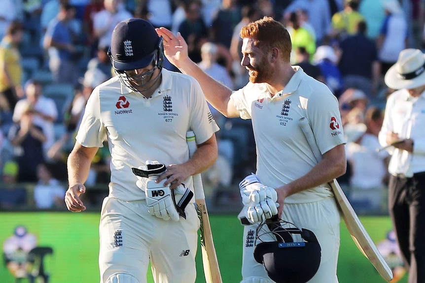Jonny Bairstow pats Dawid Malan on the back as they leave the field.