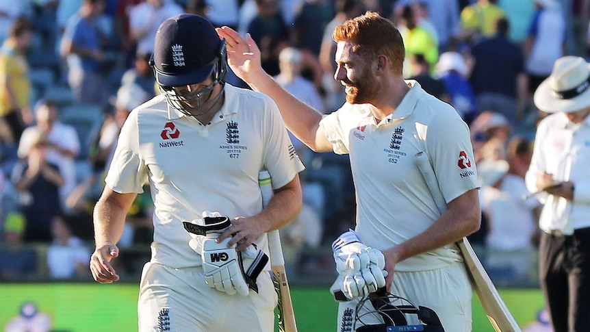 Jonny Bairstow pats Dawid Malan on the back as they leave the field.