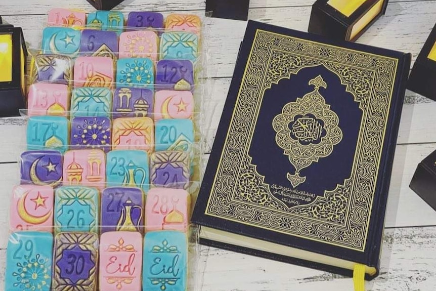 A box of colourful cookies next to the Koran.