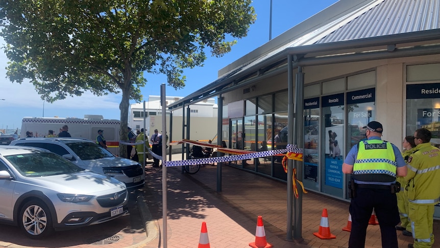 POlice and poice tape in front of the window of Mark McGowan's electorate office