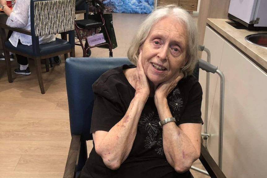 Dulcie Veltman sitting at a table in an aged care home.