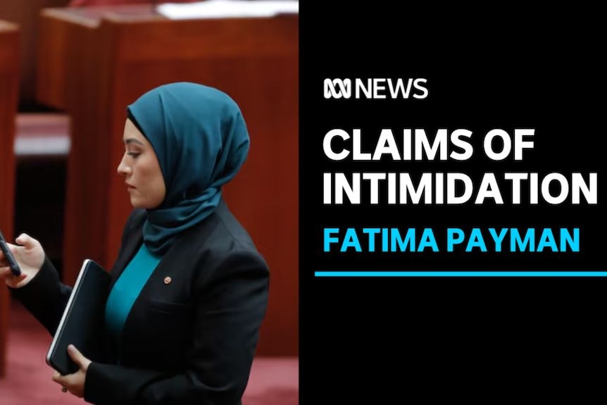 Claims of Intimidation, Fatima Payman: A woman in a headscarf in the senate looking at her phone.