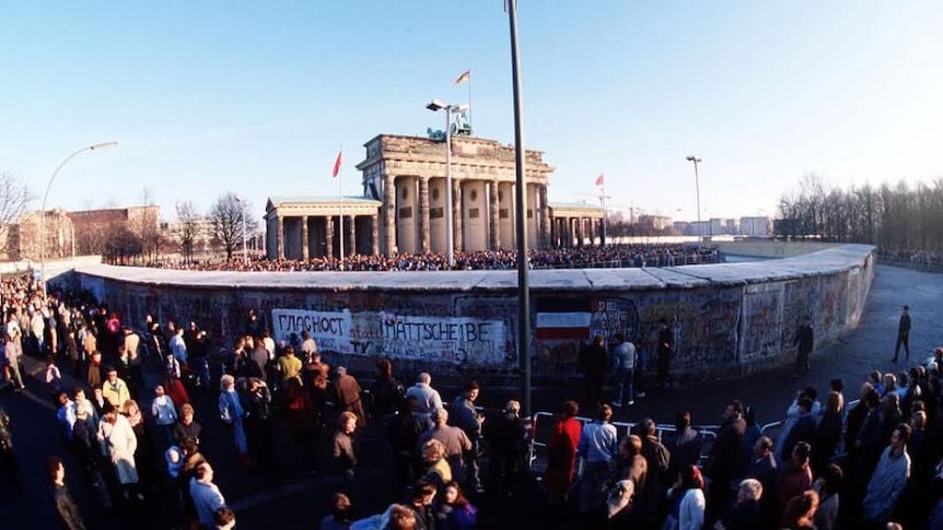 Large crowd stands beside Berlin Wall