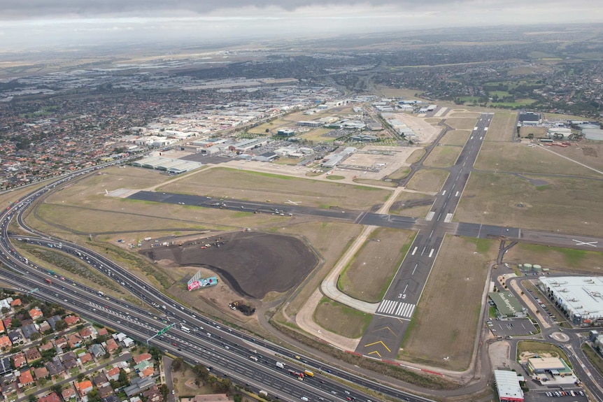 An aerial view of Essendon airport, showing freeways and houses surrounding the airfield and runways.