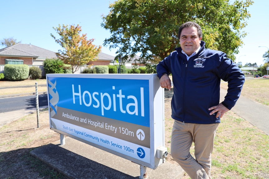 Man standing by hospital sign