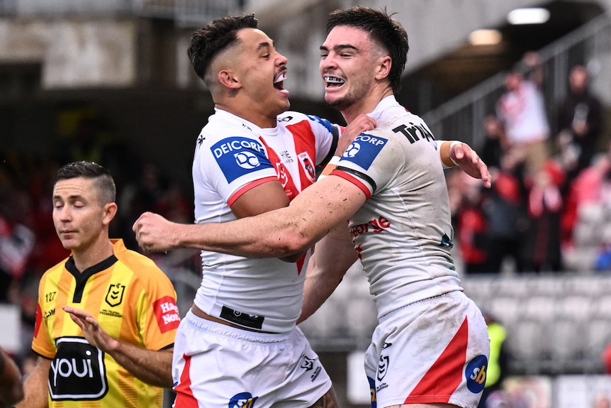 Two St George Illawarra NRL players embrace as they jump in the air as they celebrate a try.