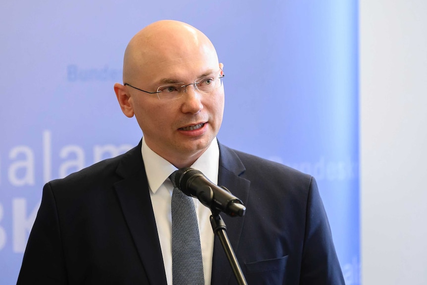 A police prosecutor speaks into a microphone during a press conference