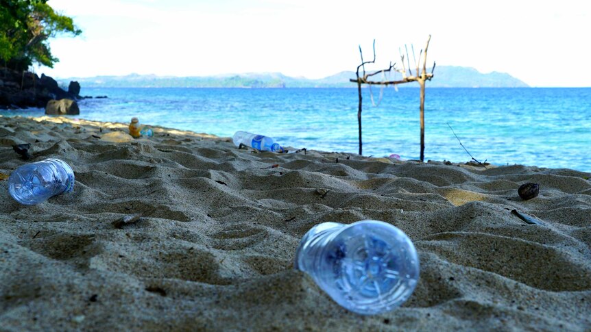 Plastic bottles littering the sand of an otherwise pristine beach
