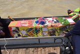 Sally Taylor's cardboard coffin decorated with memorabilia from her life before being taken across Lake Albert in a dragon boat