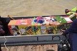 Sally Taylor's cardboard coffin decorated with memorabilia from her life before being taken across Lake Albert in a dragon boat