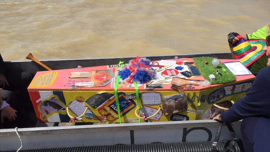 Sally Taylor's cardboard casket decorated with memorabilia from her life before being taken across Lake Albert in a dragon boat