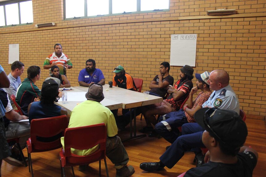 A photo of Brendon Adams speaking to a table of Indigenous men at the Wilcannia men's group meeting.
