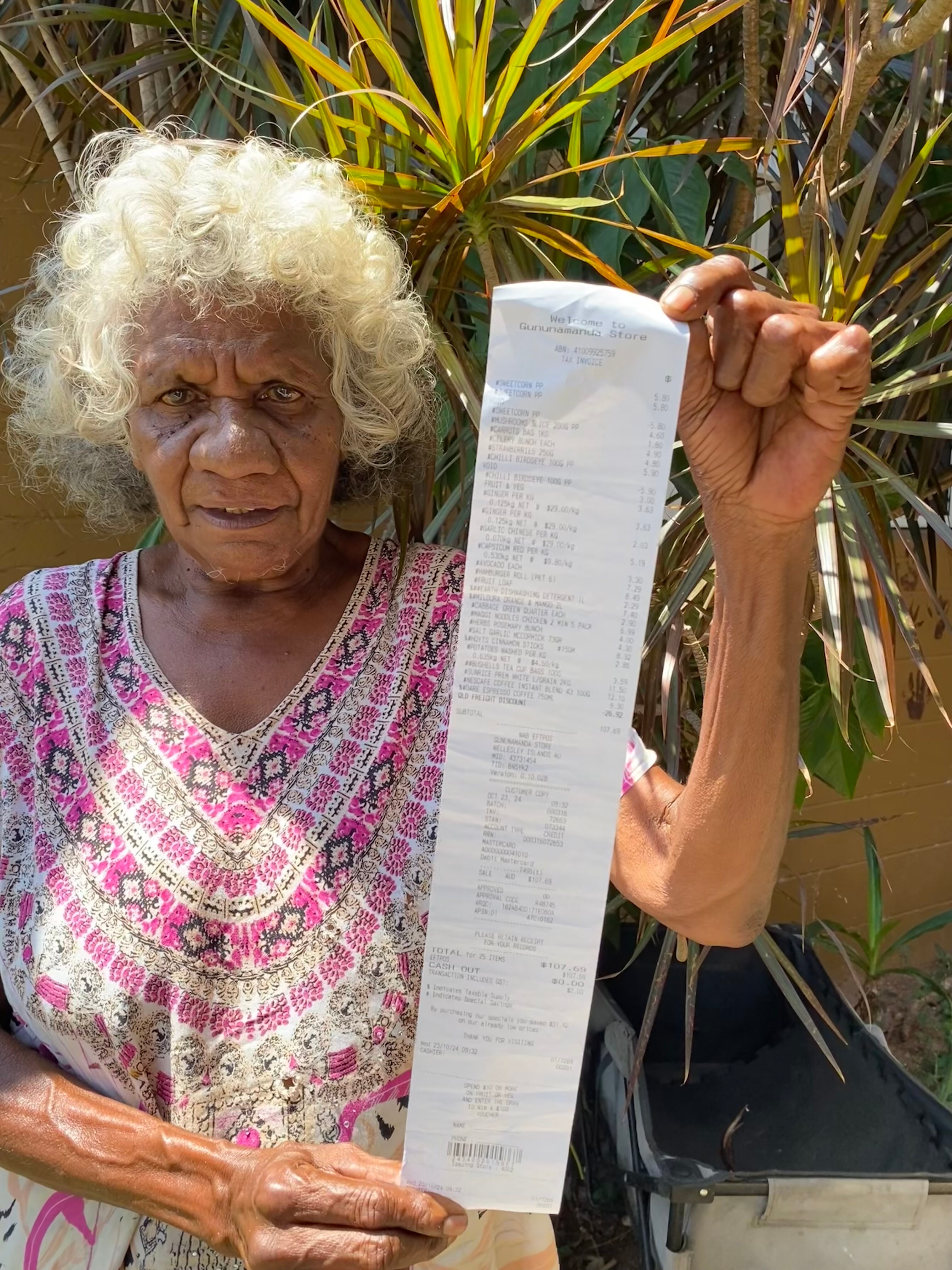 Woman holds up receipt to camera