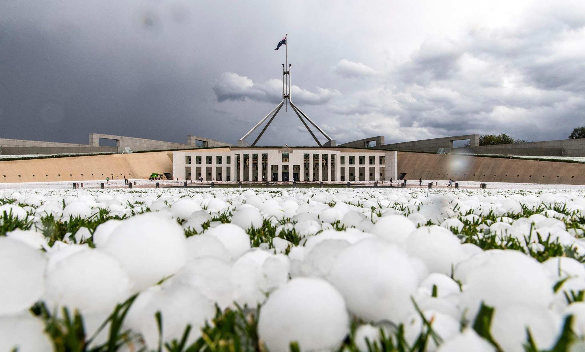Large hailstone lie in the foreground with parliament in the background.