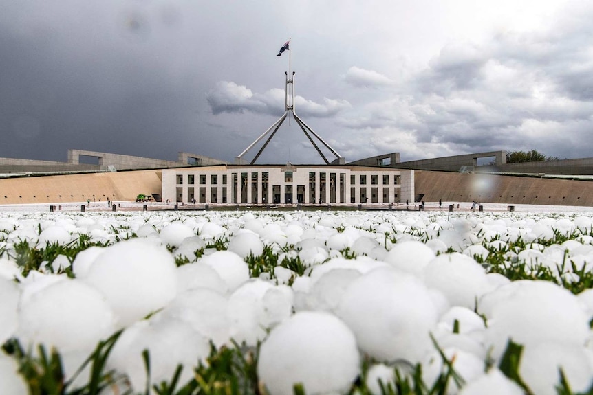 Large hailstone lie in the foreground with parliament in the background.
