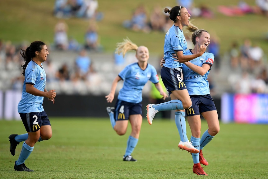 Chloe Logarzo jumps in the air as she celebrates a goal with teammates.