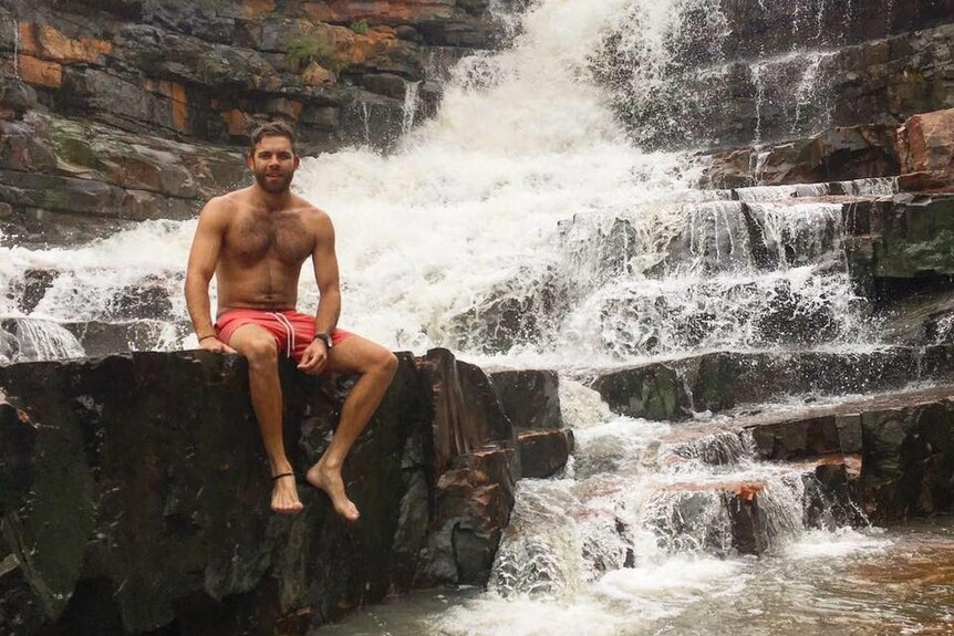 John Young sits in front of a waterfall. He drowned swimming at a Ord River crossing.