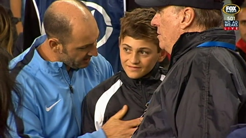 Sydney FC officials talk to the ball boy.