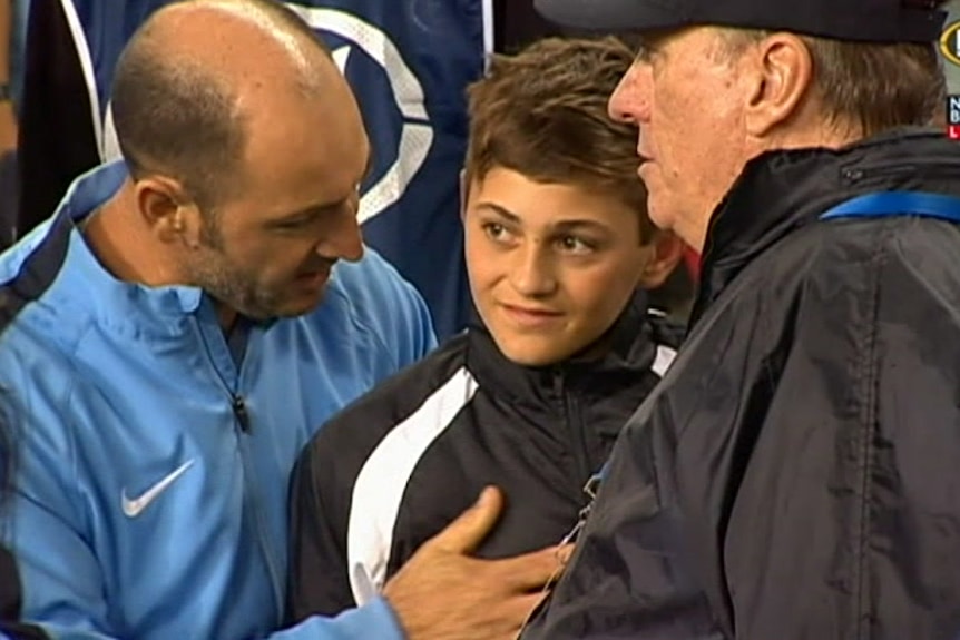 Sydney FC officials talk to the ball boy.