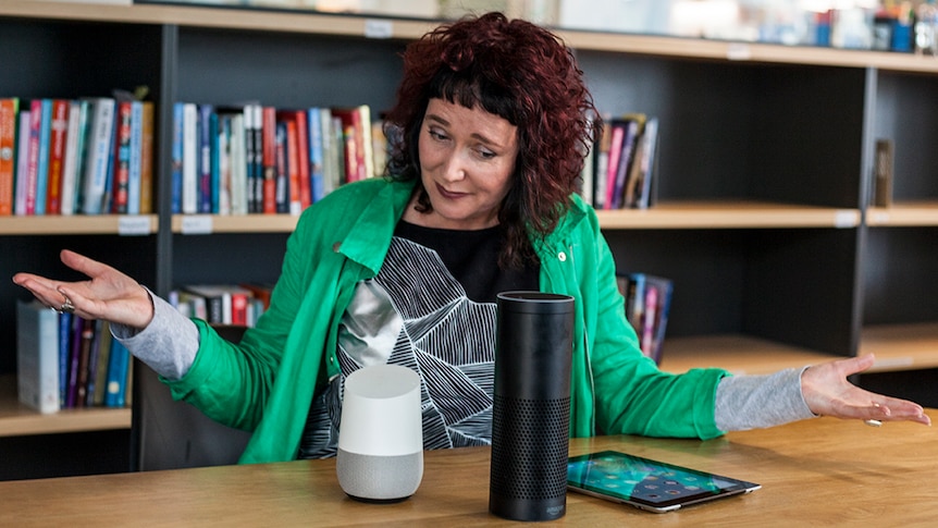 A woman raises her arms in confusion, while looking at three virtual assistant units.