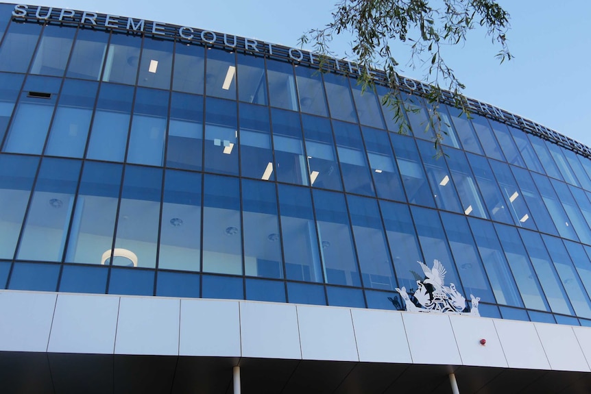 A large glass-panelled building that says Supreme Court of the Northern Territory.