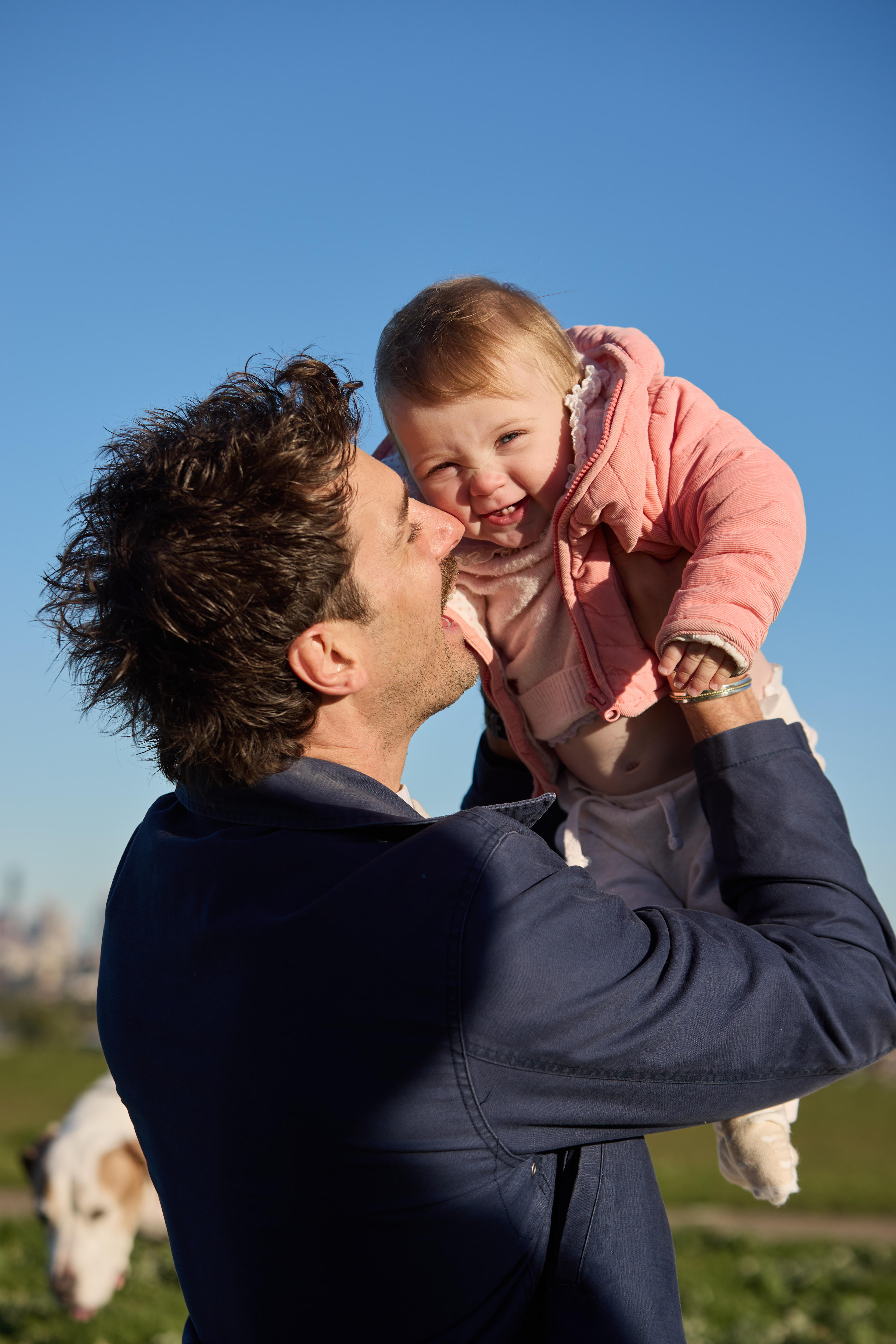 A man lifts up his smiling baby