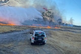 a four wheel drive car driving towards a bushfire 
